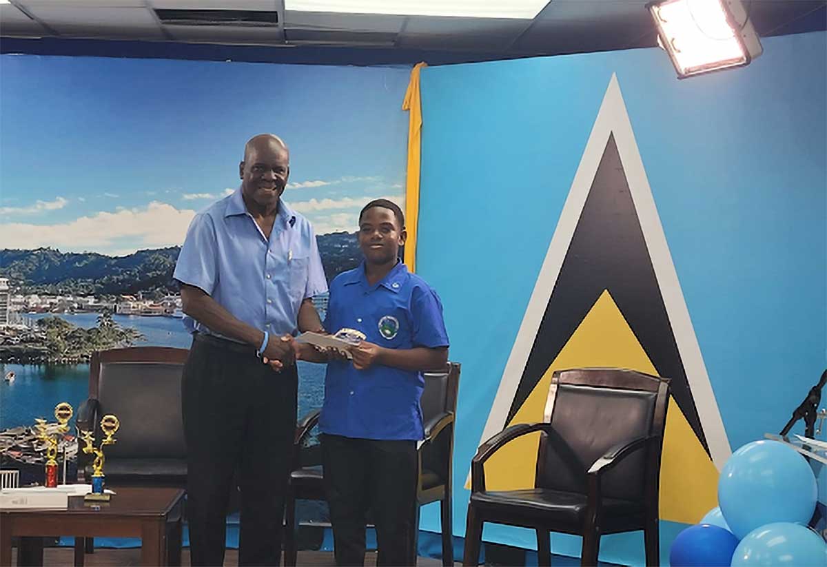 Vice President of the St. Lucia Diabetes and Hypertension Association Tedburt Theobalds (L) with the winner of the National Primary Schools Diabetes Quiz Competition Shanil Solomon of the Soufriere Primary School.