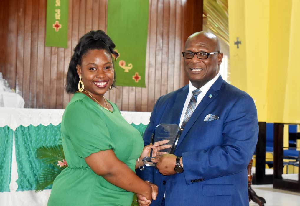 The VOICE Publishing Company representative Tricia Jn Baptiste accepting an award from Infrastructure Minister Stephenson King